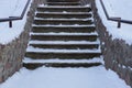 Old gray concrete staircase with stone steps under white snow Royalty Free Stock Photo