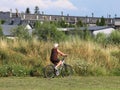 An old gray-haired woman rides a bicycle among the greens. A healthy and active part of life. Ecological transport for the populat