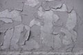 Old gray peeling paint on a concrete wall with cracks and scratches. rough surface texture