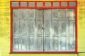 Old gray-red wooden door on yellow wooden wall Royalty Free Stock Photo