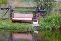 Old gray sofa in the grass on the lake shore