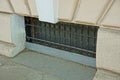 Old gray window basement with grating by the sidewalk