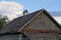 Old gray wooden attic of a rural house with a small window under a  slate roof Royalty Free Stock Photo