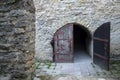 Old gray wooden double door in an ancient authentic stone wall. Gothic style Fortress. Vintage Royalty Free Stock Photo