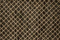 Old gray wooden wall behind a rusty metal rhombic grate. Background, texture Royalty Free Stock Photo