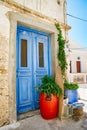 Old Blue doors with a red flower pot