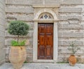 An old Greek orthodox church natural wood door on stone wall and potted plants. Royalty Free Stock Photo