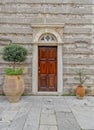 An old Greek orthodox church natural wood door on stone wall and potted plants. Royalty Free Stock Photo