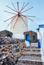 Old greek windmill on Santorini island in Oia town with stairs in street. Santorini, Greece