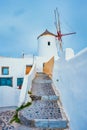 Old greek windmill on Santorini island in Oia town with stairs in street. Santorini, Greece Royalty Free Stock Photo