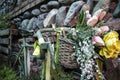 an old green bicycle with a basket of flowers by a stone wall made of bricks and stones Royalty Free Stock Photo