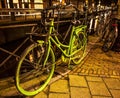 Old green bicycle parked near bridge in Amsterdam at night. Royalty Free Stock Photo