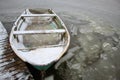 Old green boat in a frozen lake. The boat is covered with snow. water froze inside the boat. Low temperature