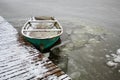 Old green boat in a frozen lake. The boat is covered with snow. water froze inside the boat. Low temperature Royalty Free Stock Photo