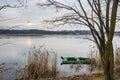 Old, green, boat submerged in the water at the bank of the pond on the Mala Panew river in Kalety Zielona in Poland