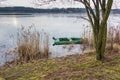 Old, green, boat submerged in the water at the bank of the pond on the Mala Panew river in Kalety Zielona in Poland