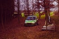 Old green car weaned in forest with sunken leaves Royalty Free Stock Photo