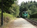 Old green diesel locomotive is approaching the station. Idyllic railway image. Summer train trip