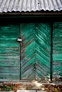 Old green door or wall of a wooden house in rustic style,with peeling paint. Royalty Free Stock Photo