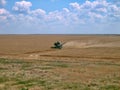 Old green harvester removes grain from the field during harvest. Royalty Free Stock Photo