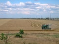 Old green harvester removes grain from the field during harvest. Royalty Free Stock Photo