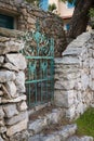 Old green iron gate, stone walls garden entrance Royalty Free Stock Photo