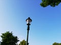 Old green lantern in the city park in Vienna Austria with blue sky and trees Royalty Free Stock Photo