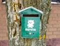 Old green mailbox in the snow on the tree. Royalty Free Stock Photo