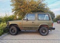 Old green offroad 4WD car Mitsubishi Pajero parked