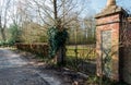 Old green painted gate between two masonry brick pillars