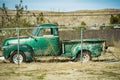 Old Green Pickup Behind A Chain Link Fence