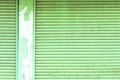 Old green roller shutter door with pole. Royalty Free Stock Photo