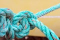 Old green rope knotted on a yellow background. Knot. Insoluble problem concept Royalty Free Stock Photo