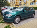 Old green rusty Nissan Almera hatchback four doors parked