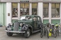 Old green 40`s car and modern bikes parked in street of picturesque 30`s Deco touristic little town, Napier, New Zealand