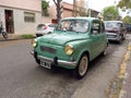 old green 1970s Fiat 600 sedan two door rear engined unibody parked in the street. Classic car show.