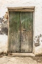 Old green timber door in the scuffed wall