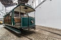 Traditional old Portuguese green tram in the depot. Perspective view of vintage wagon with open driver cockpit and copper lantern Royalty Free Stock Photo