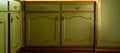 Old green vintage kitchen cupboard close-up, antique retro desing of closet doors background tecxture stylish