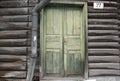 The old green wood door of old log house and water drain