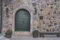 Old green wooden door with bolt with castle wall texture Royalty Free Stock Photo