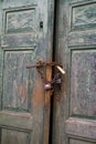 Old green wooden door with rusty chain and padlock Royalty Free Stock Photo