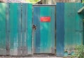 Old green wooden fence and locked door with text `Staff Only` on red label Royalty Free Stock Photo