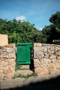 Old green wooden gate with stone fence Royalty Free Stock Photo