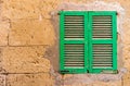 Old green wooden window shutter and stone wall Royalty Free Stock Photo
