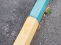 Old green and yellow painted kerbstone Royalty Free Stock Photo