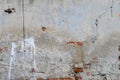 Old grey concrete garage wall with red bricks cracks and spots Royalty Free Stock Photo