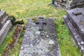 Old grey cross on tomb at cemetery