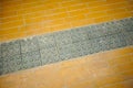 Old grey non-slip mat on orange brick floor