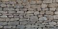 Old Grey stone wall made of large gray small rectangular hewn natural stones Royalty Free Stock Photo